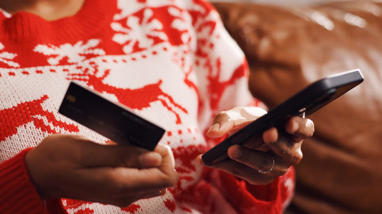 a woman holding a cell phone and a credit card