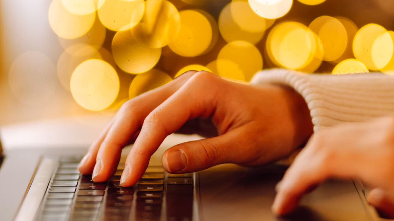 a woman's hand touching the keys on her laptop