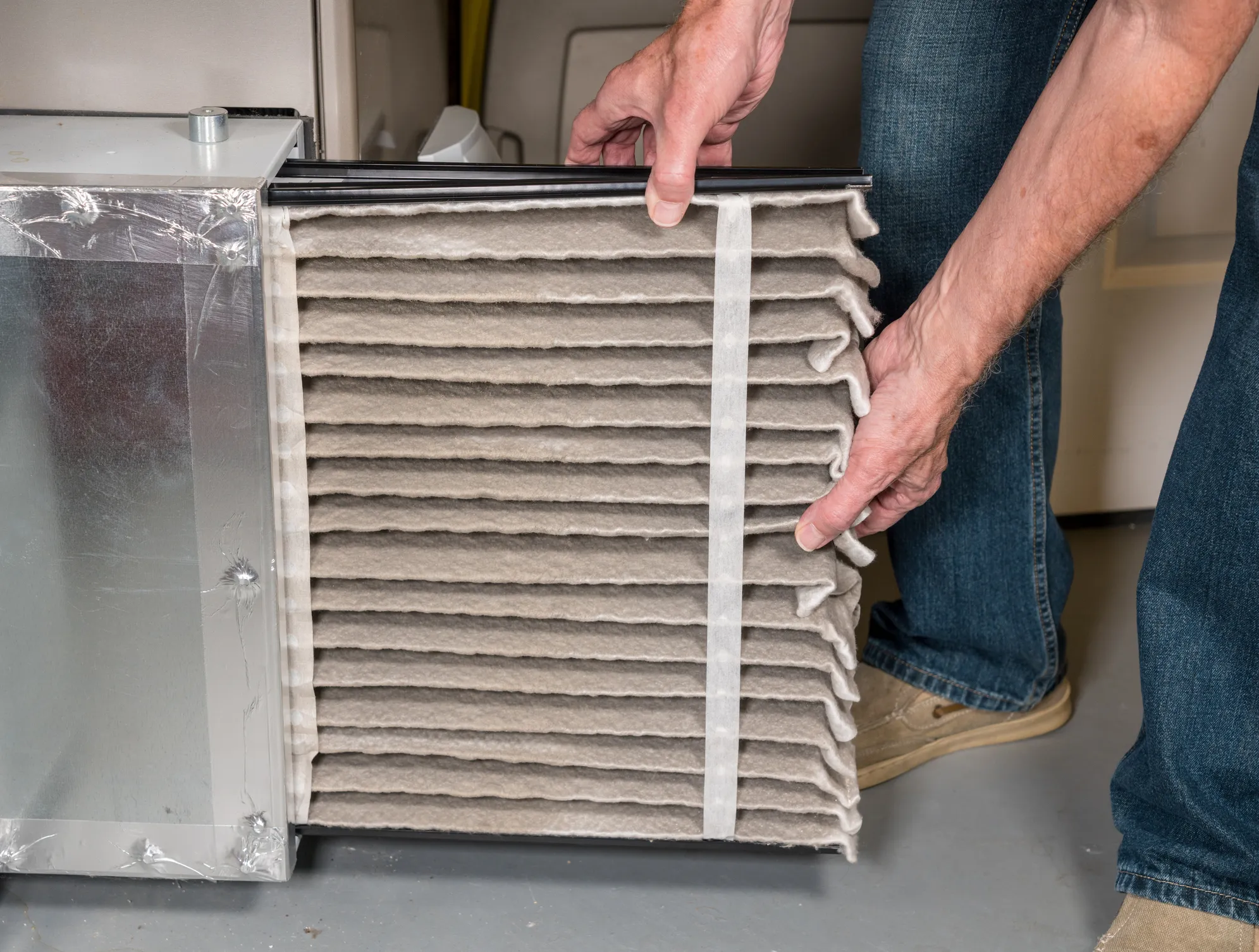 A man holding an opened Indoor Ac part