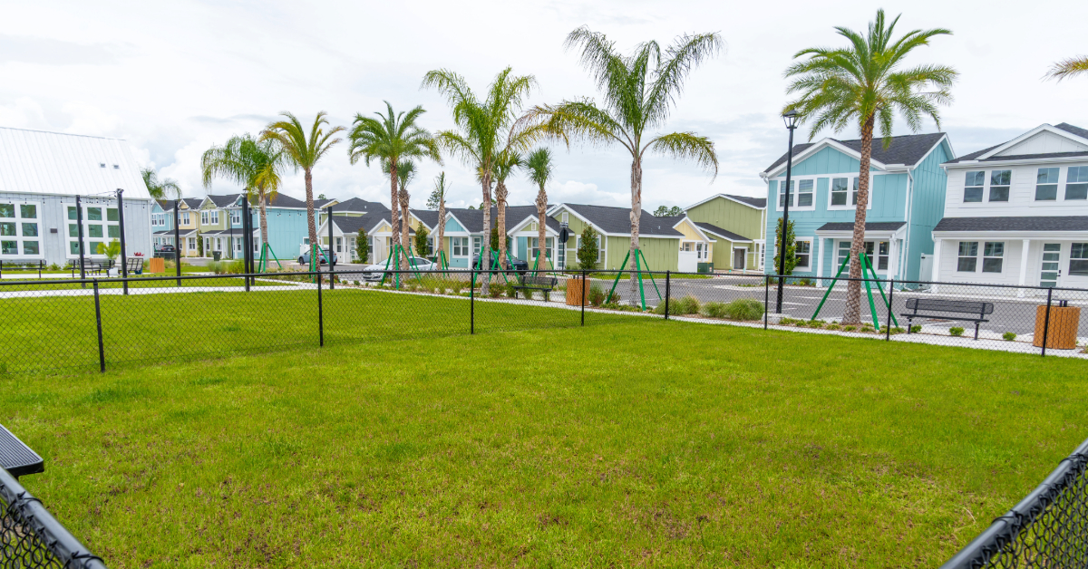 Resident fitness center with various cardio machines, free weights, and a view of the pool area, a key amenity at The Eleanor Daytona Beach in Daytona Beach, Florida.