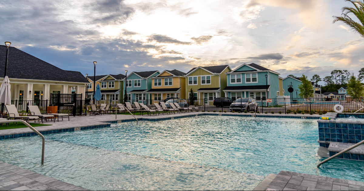 Stylish resident lounge with a fireplace, bar seating, and comfortable chairs, showcasing a community amenity at The Eleanor Daytona Beach in Daytona Beach, Florida.