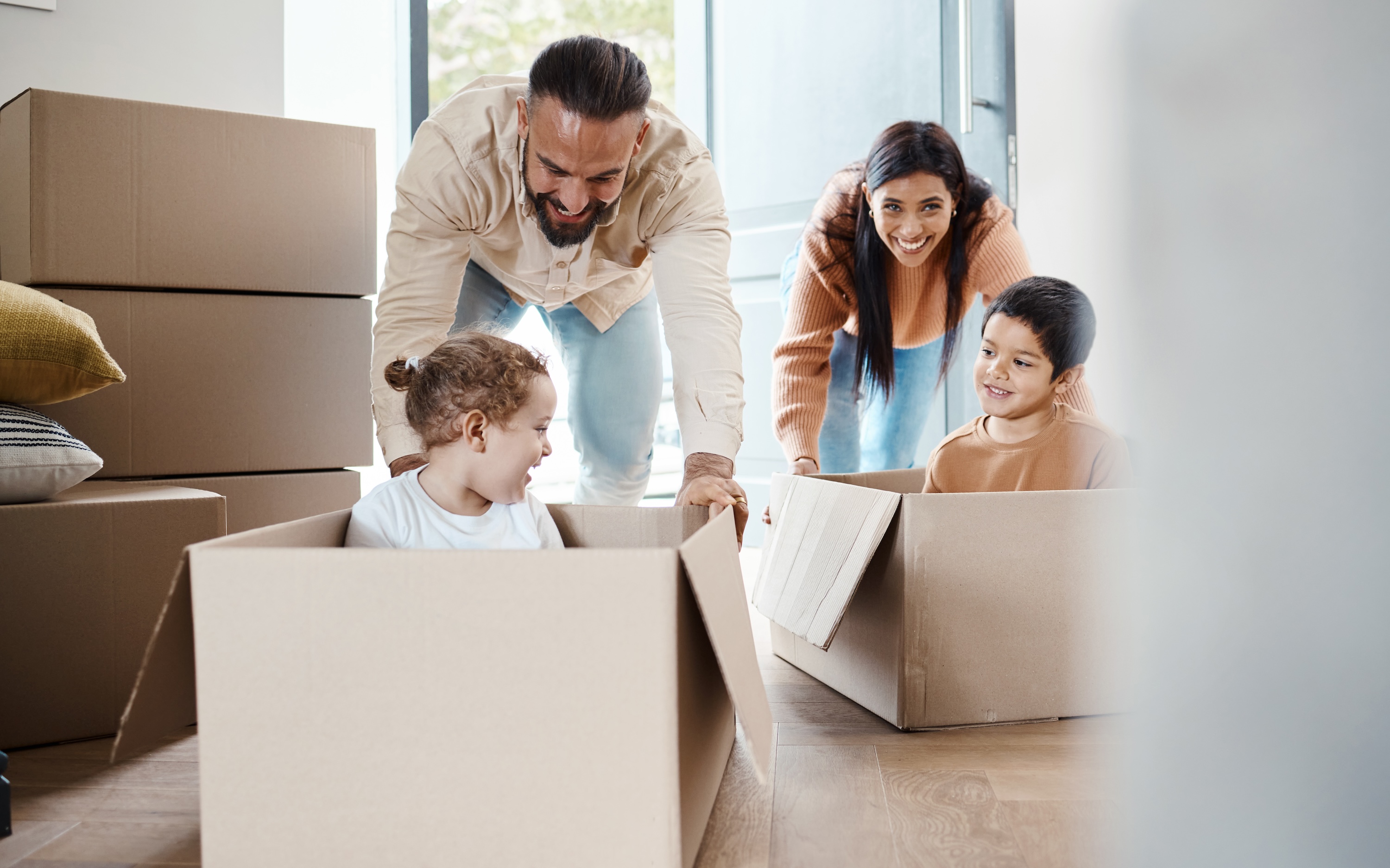 Adults and children playing with moving boxes in a bright entryway at The Eleanor Daytona Beach