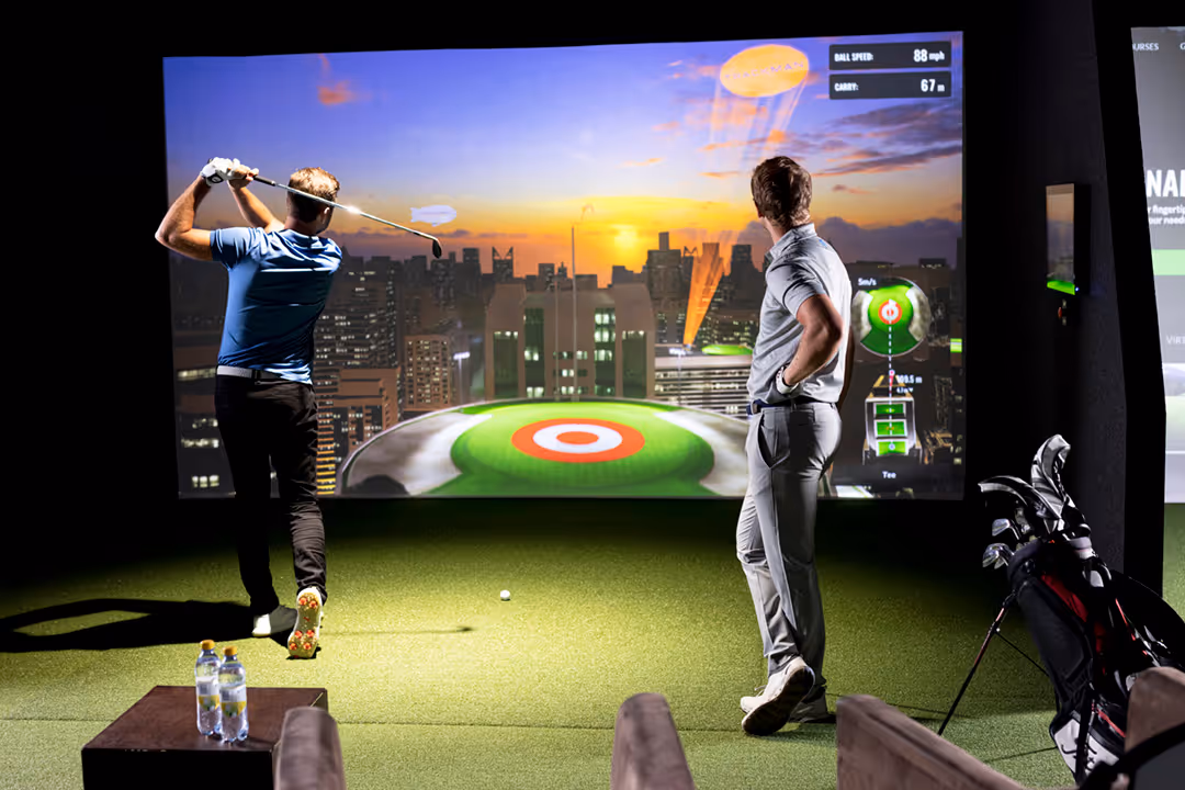 Two men playing virtual golf indoors