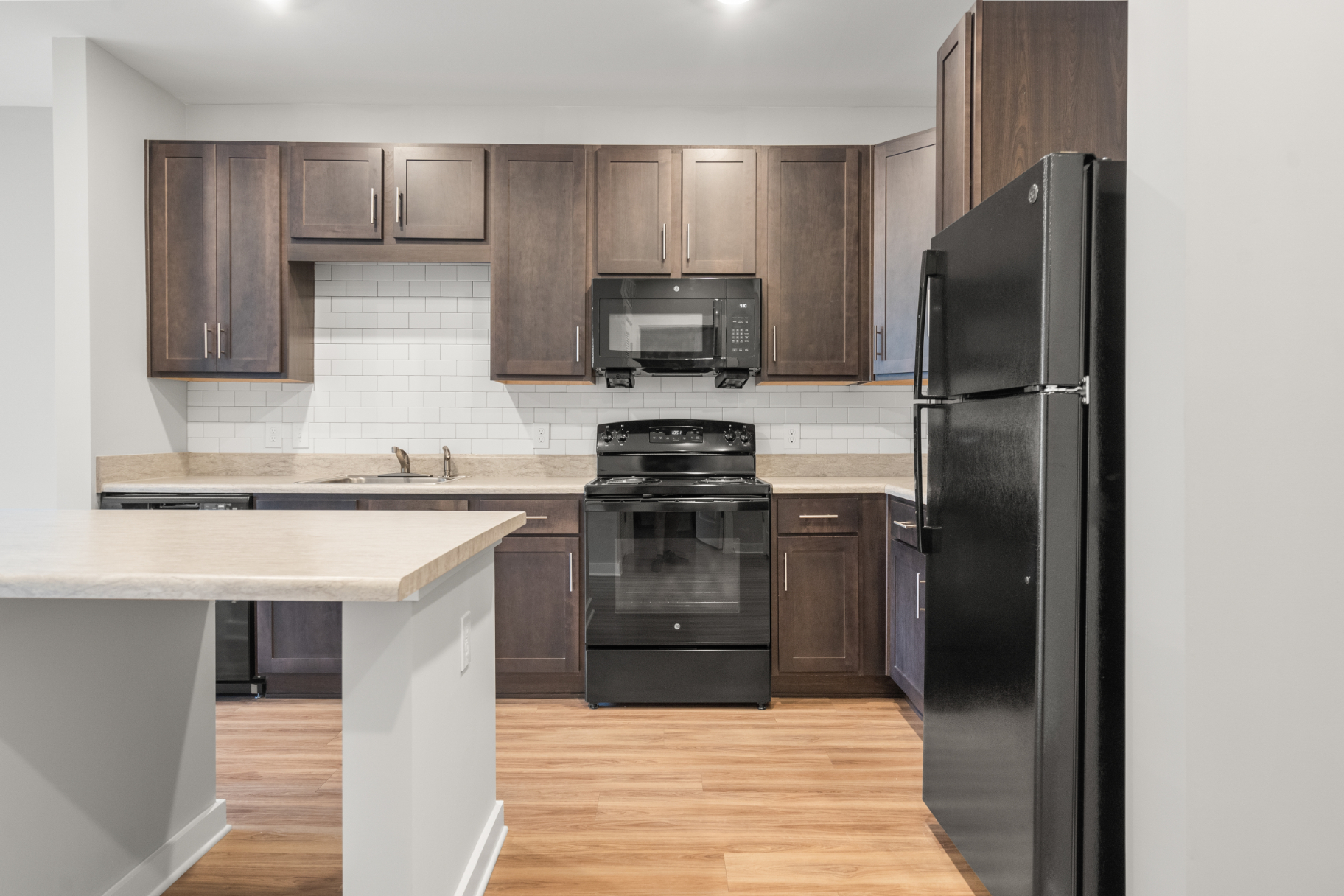 Kitchen with island, brown cabinets and black appliances