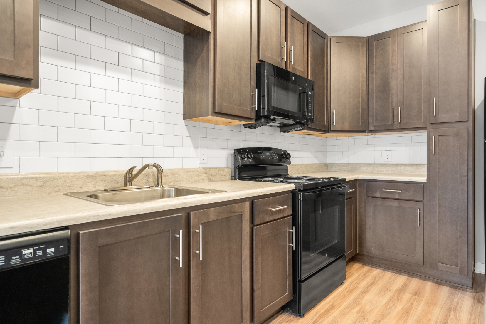 Kitchen with island, brown cabinets and black appliances