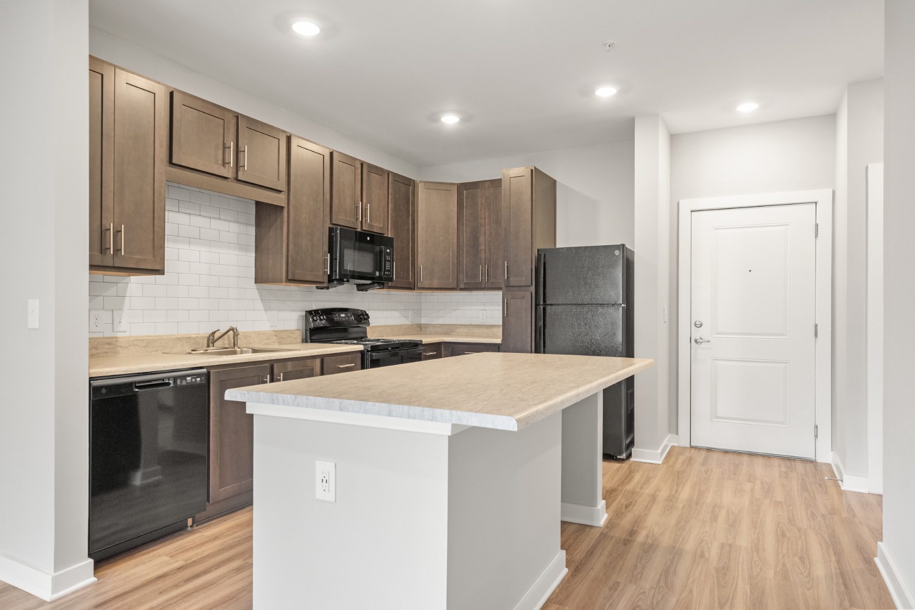 Kitchen with island, brown cabinets and black appliances