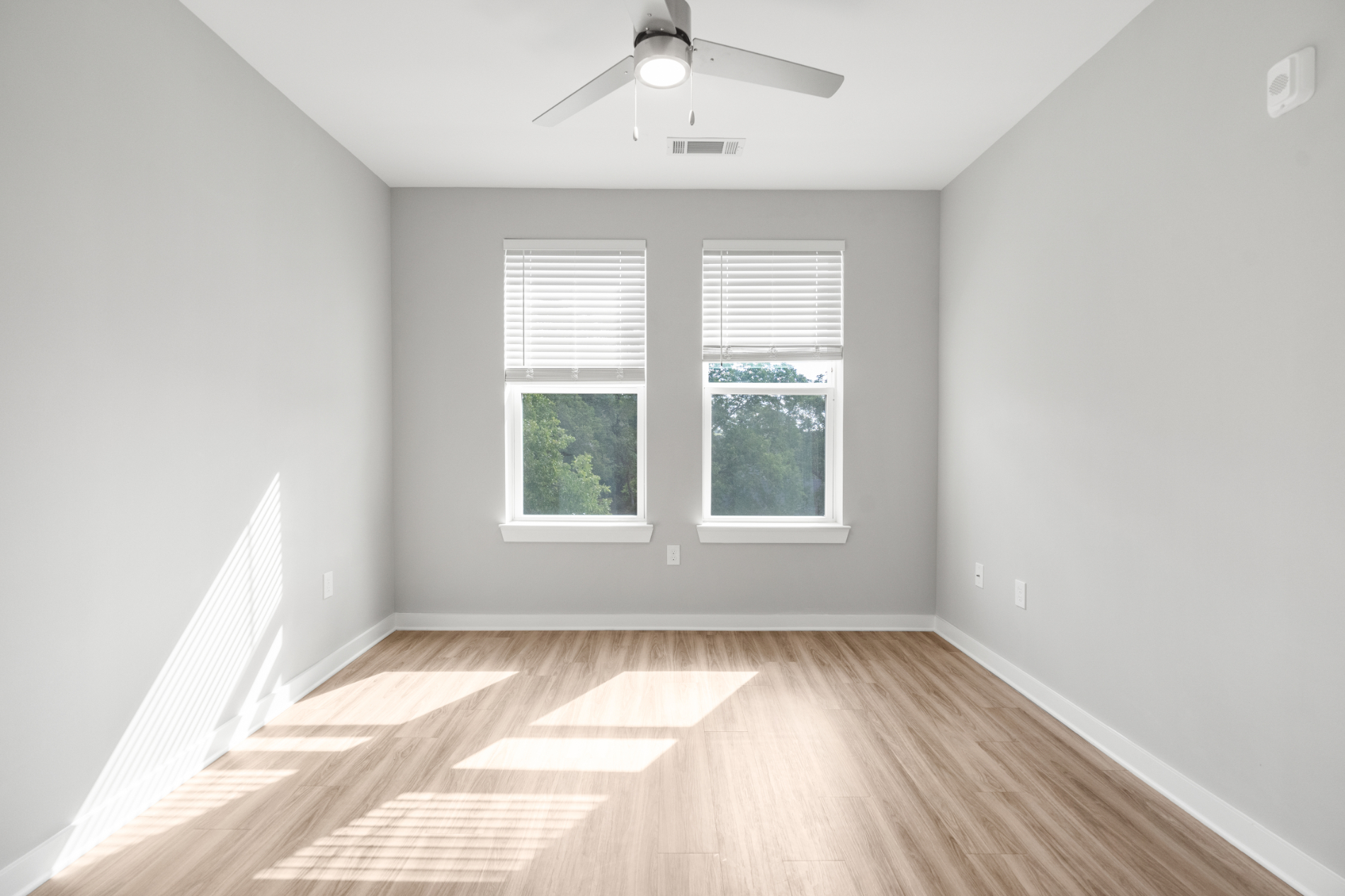 Unfurnished bedroom with ceiling fan and large window
