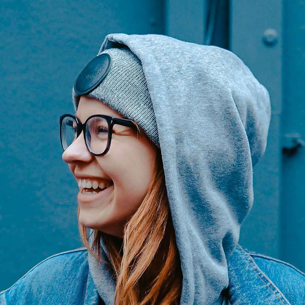 A woman wearing glasses and a blue hoodie.