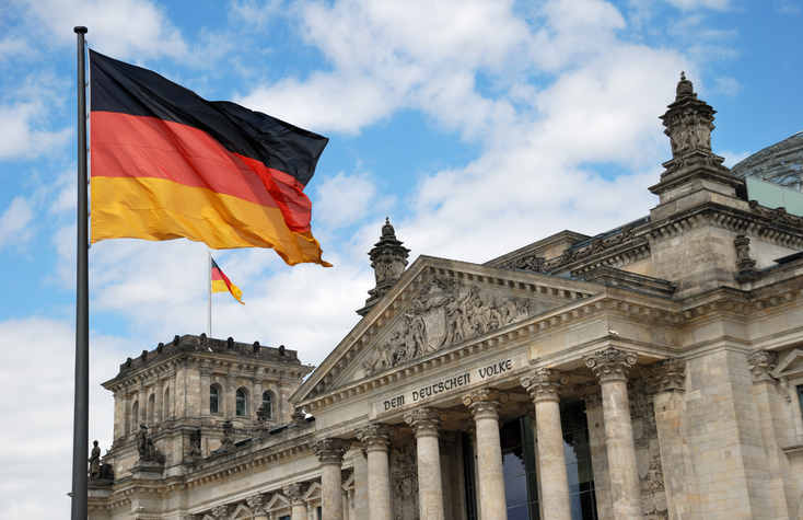 Beglaubigte Übersetzung von Einbürgerungsurkunden für deutsche Behörden – Reichstag mit Deutschlandflagge