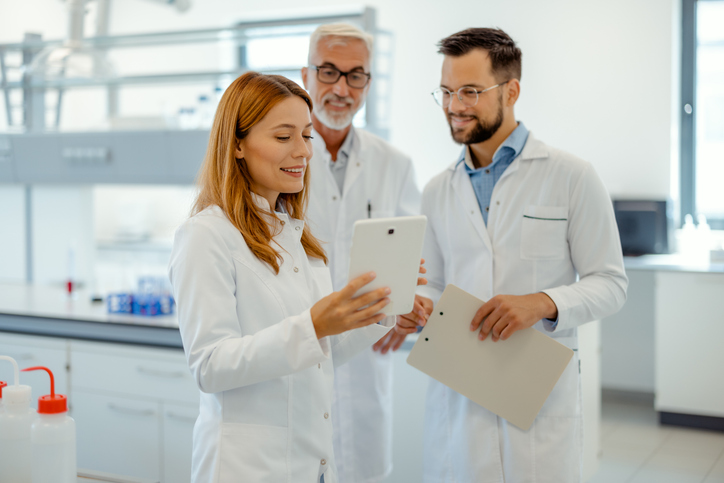 Fachübersetzer mit medizinischem Know-how: Ärzteteam bespricht medizinische Dokumente auf Tablet.