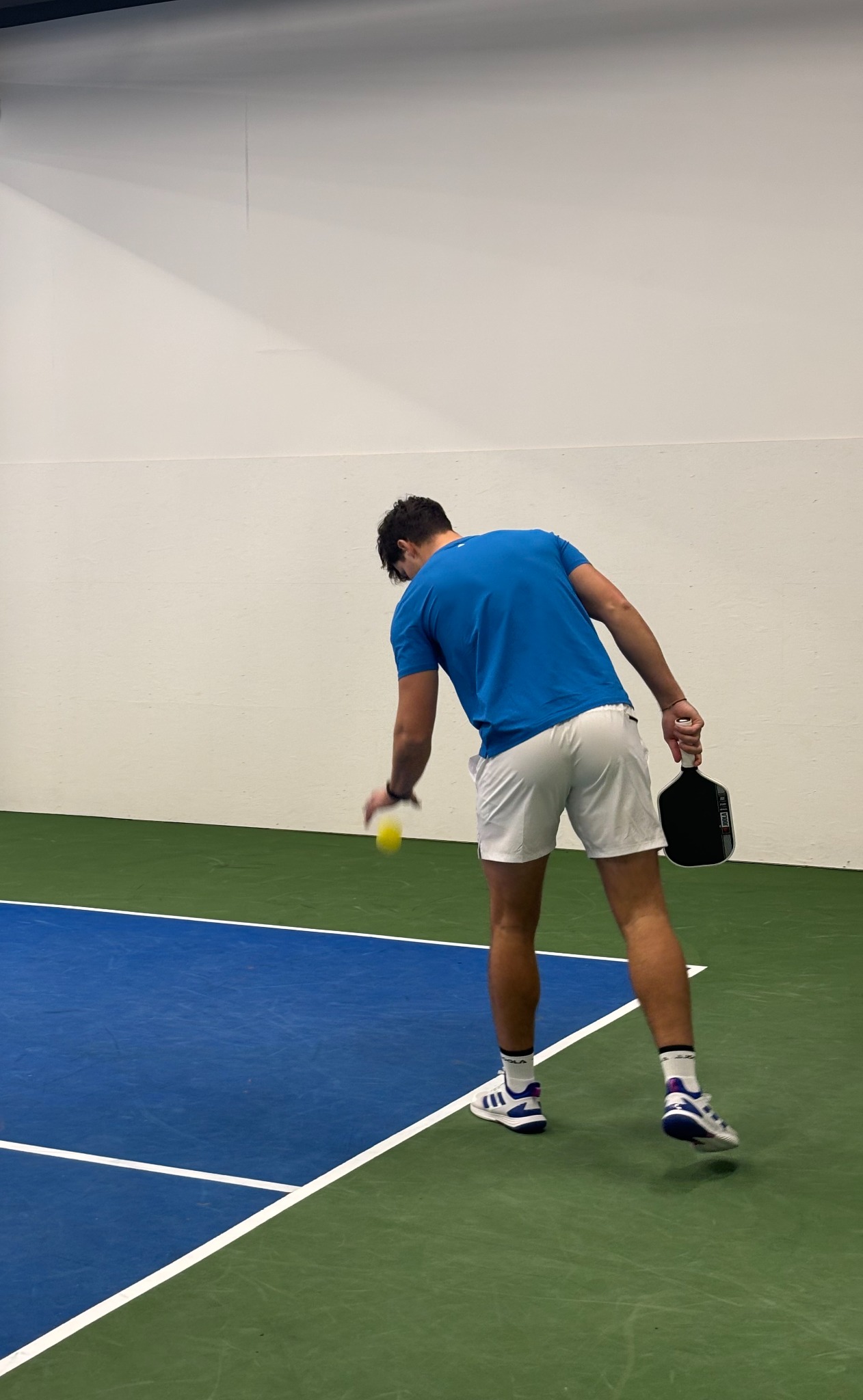 Igralec se pripravlja na servis na pokritem pickleball igrišču SportSpace Šiška
