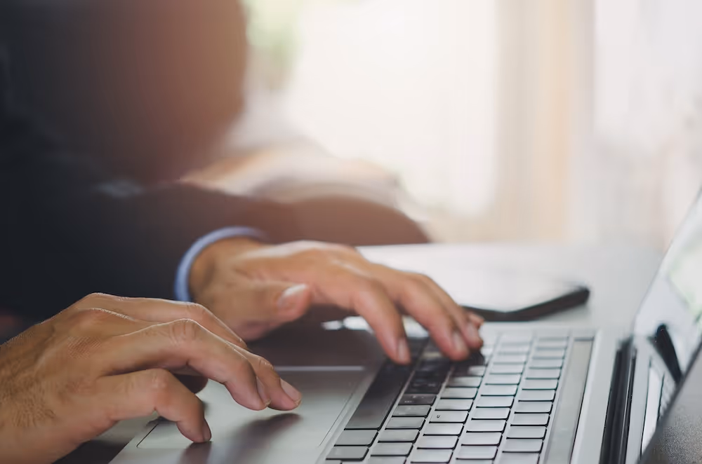 person working on a laptop in a bright los angeles psychiatry clinic office - Marc A. Heiser, MD. PHD