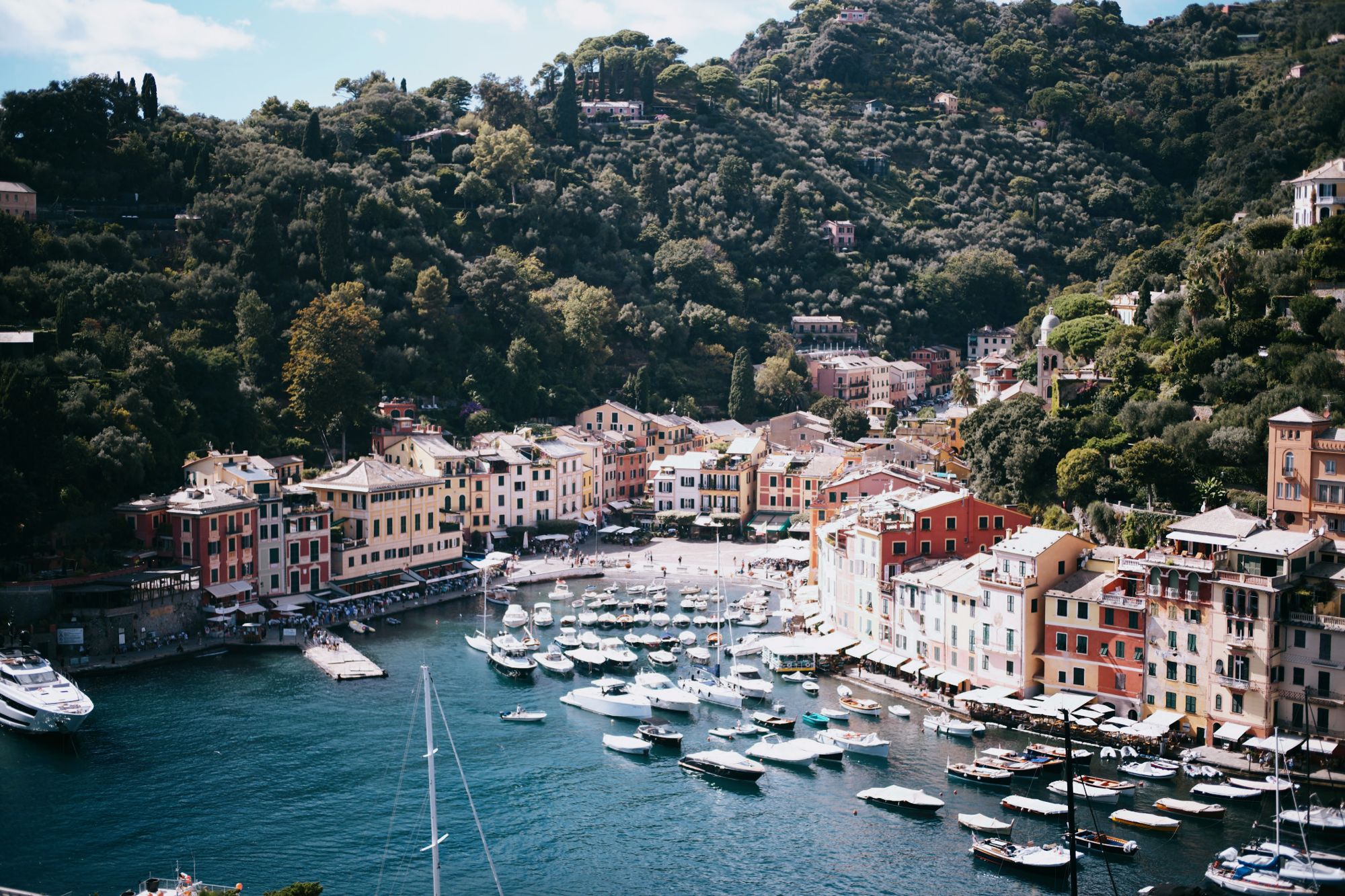 Pastel houses and moored boats around the harbour of Portofino on the Italian Riviera.