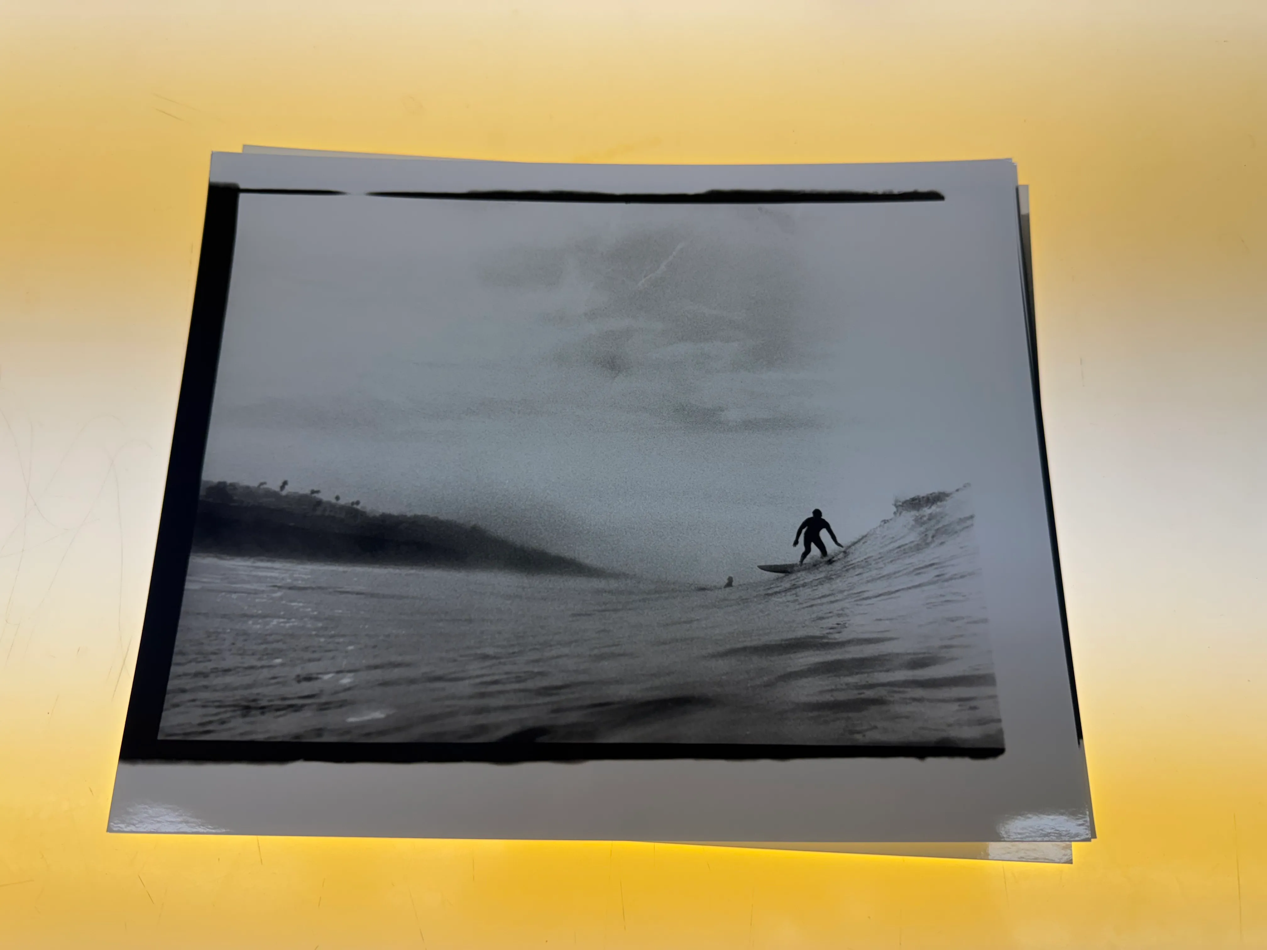 Black-and-white surfing print displayed in a darkroom.