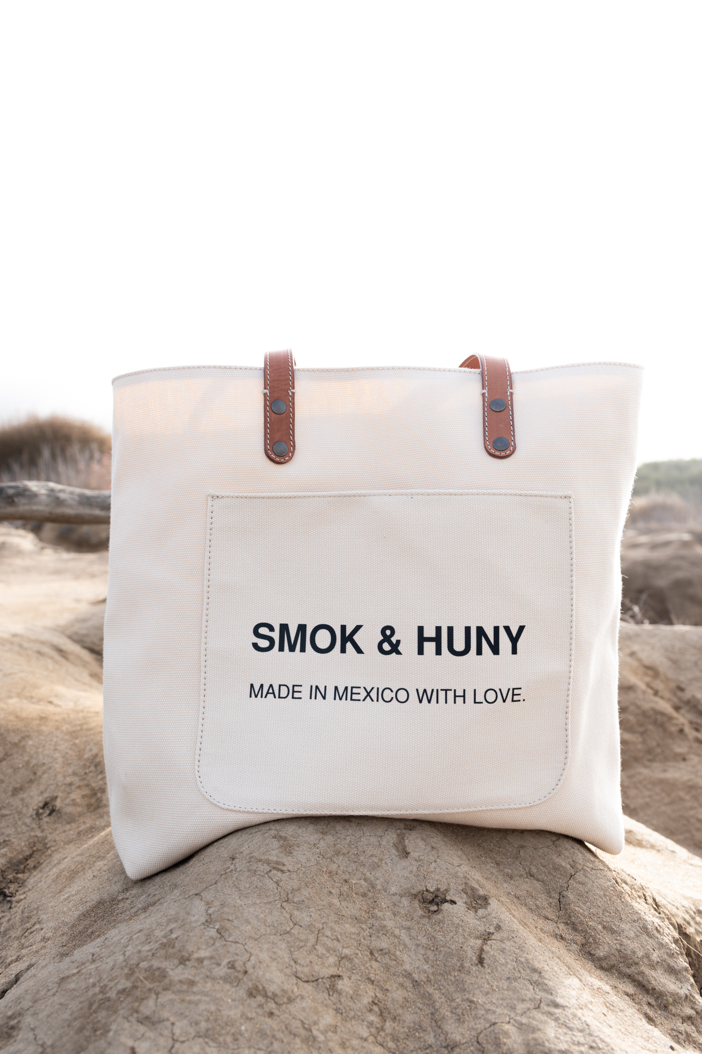Commercial product photography of a SMOK and HUNY canvas tote bag shot on location at Sunset Cliffs San Diego by Kanyon Studio