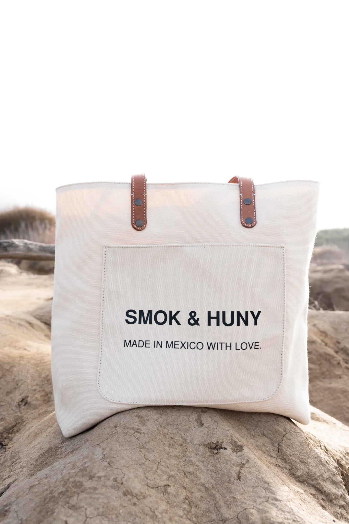 Commercial product photography of a SMOK and HUNY canvas tote bag shot on location at Sunset Cliffs San Diego by Kanyon Studio