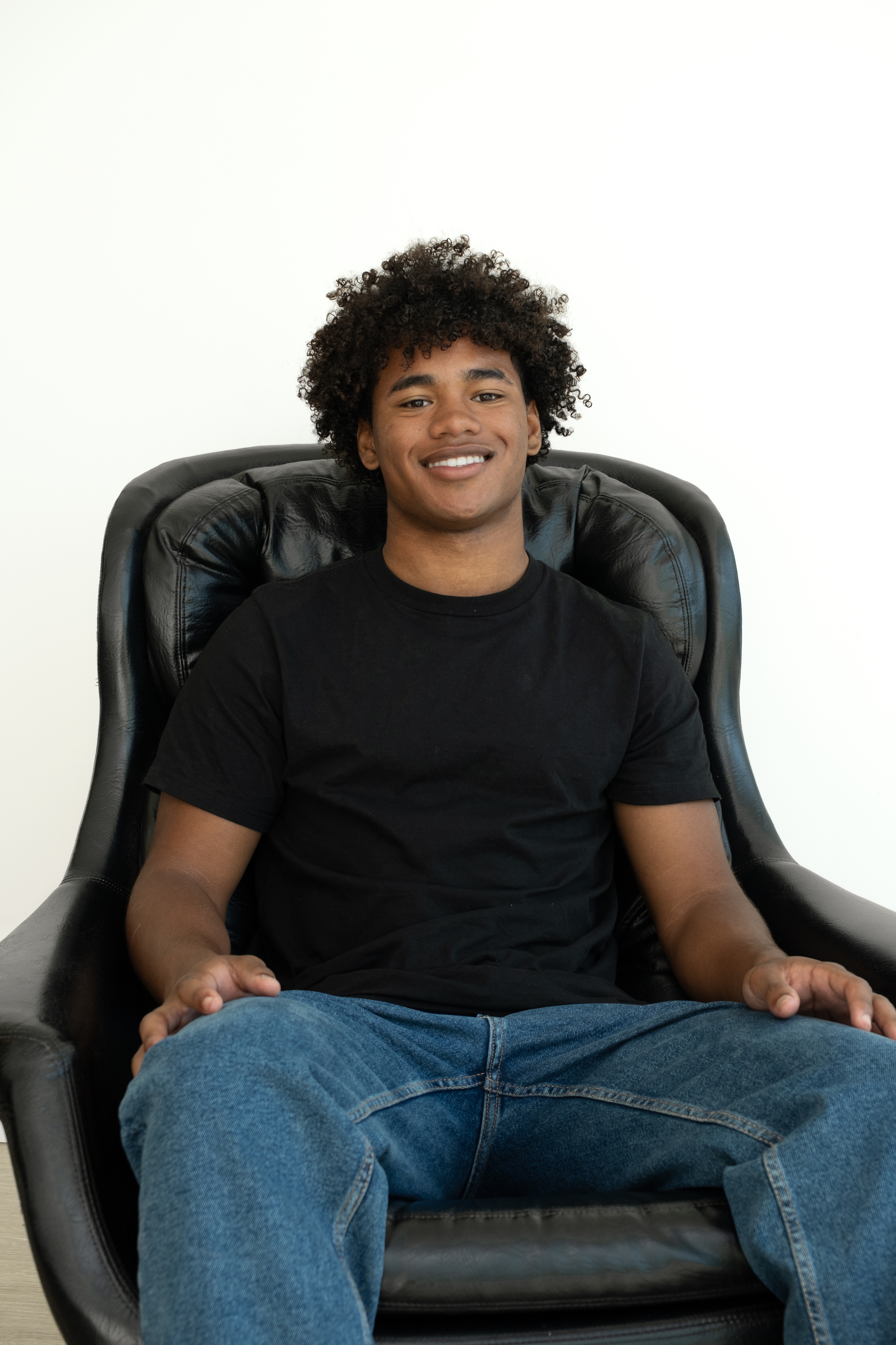 Front-facing close-up with a neutral expression, white T-shirt and plain white background.