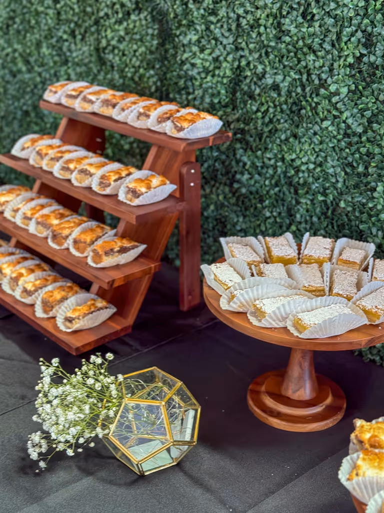 Tiered wooden dessert display with pastries and individual treats by Villani's Bakery