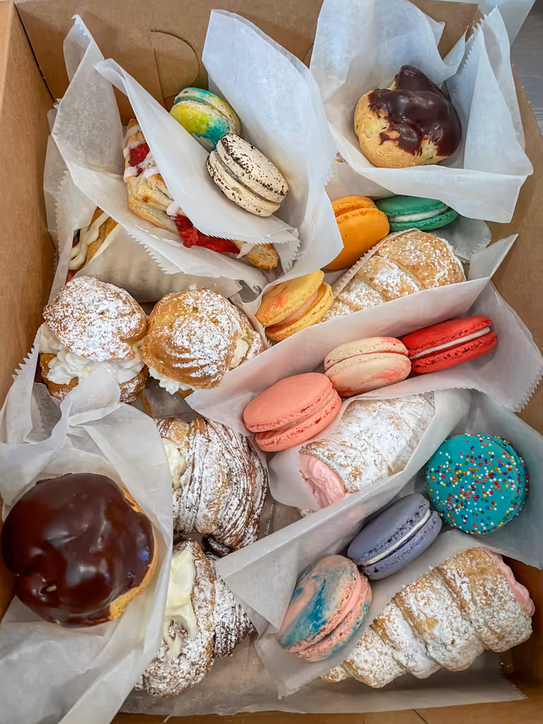 Assorted pastry box with macarons, cream puffs, and French pastries from Villani's Bakery