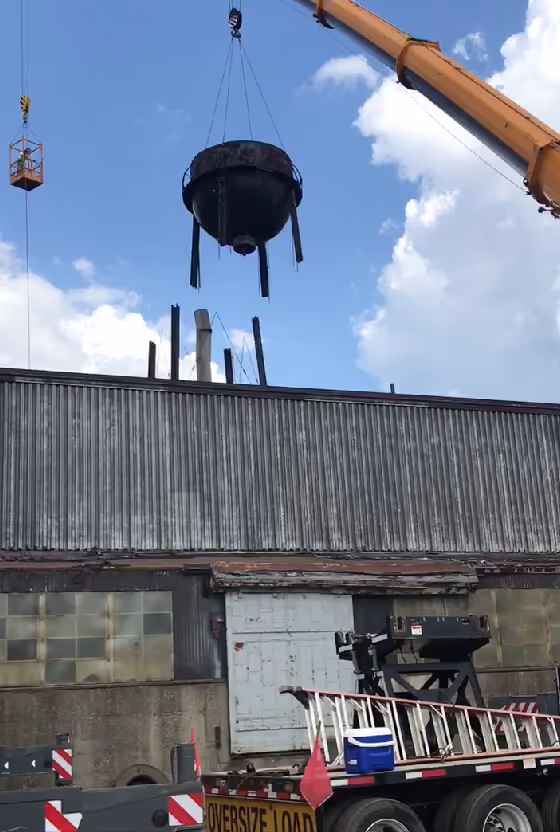 A crane lifting a large magic scrap from a demo site.