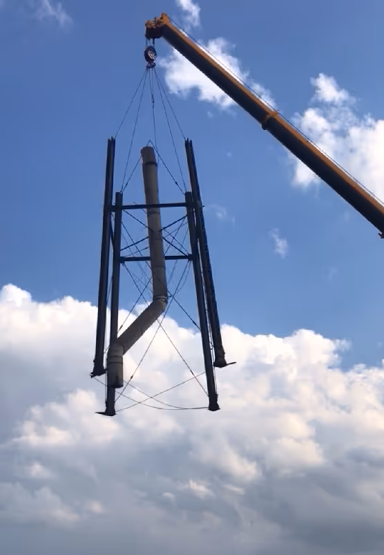A crane lifting a large metal scrap.
