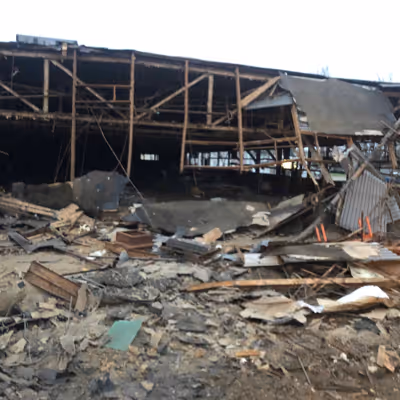 Ruins of a destroyed building, with debris scattered and walls partially collapsed.