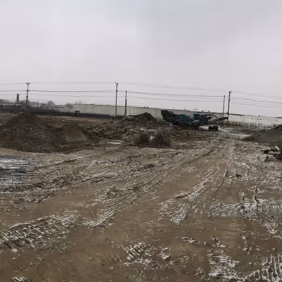 A baron area with a construction truck in the background.