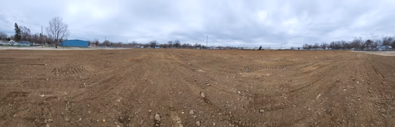 A cleaned up, flat, empty dirt area ready for use.