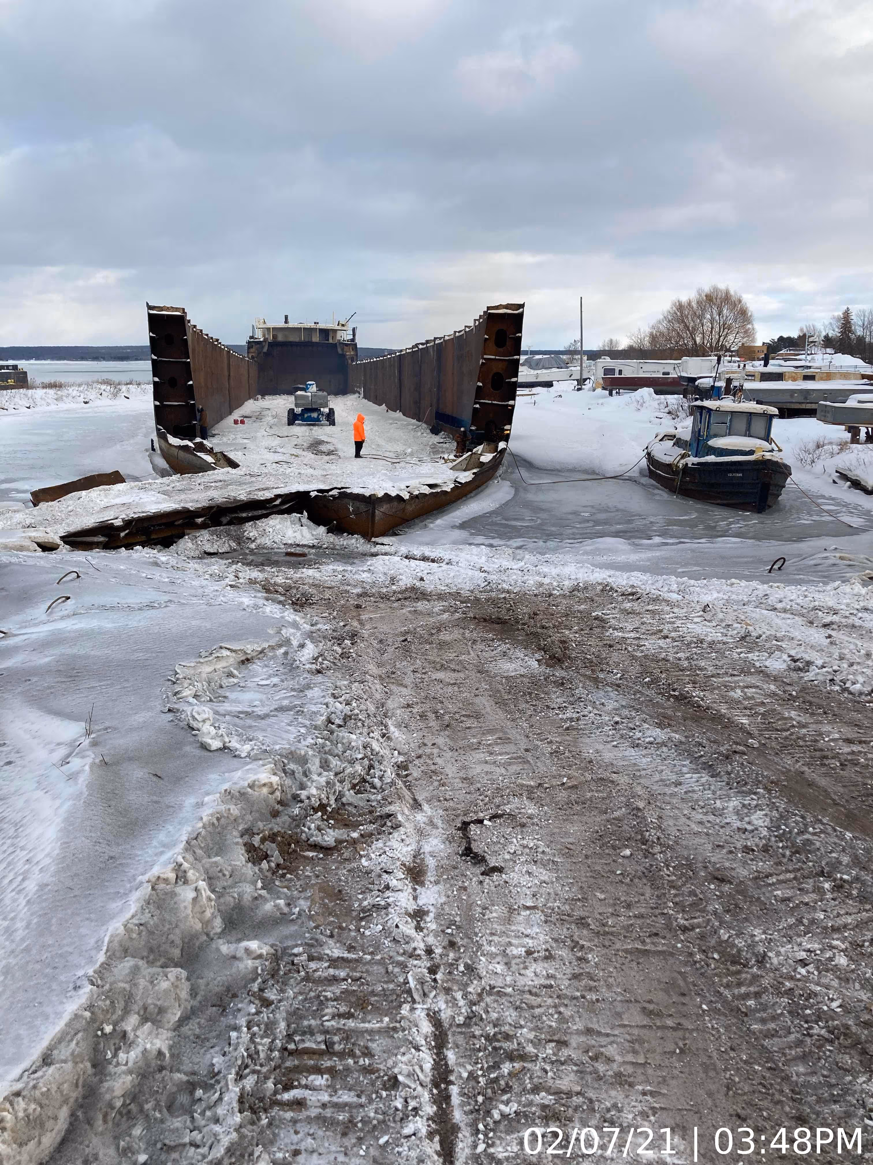 A large hollowed out ship on the ground ready to be recycled.