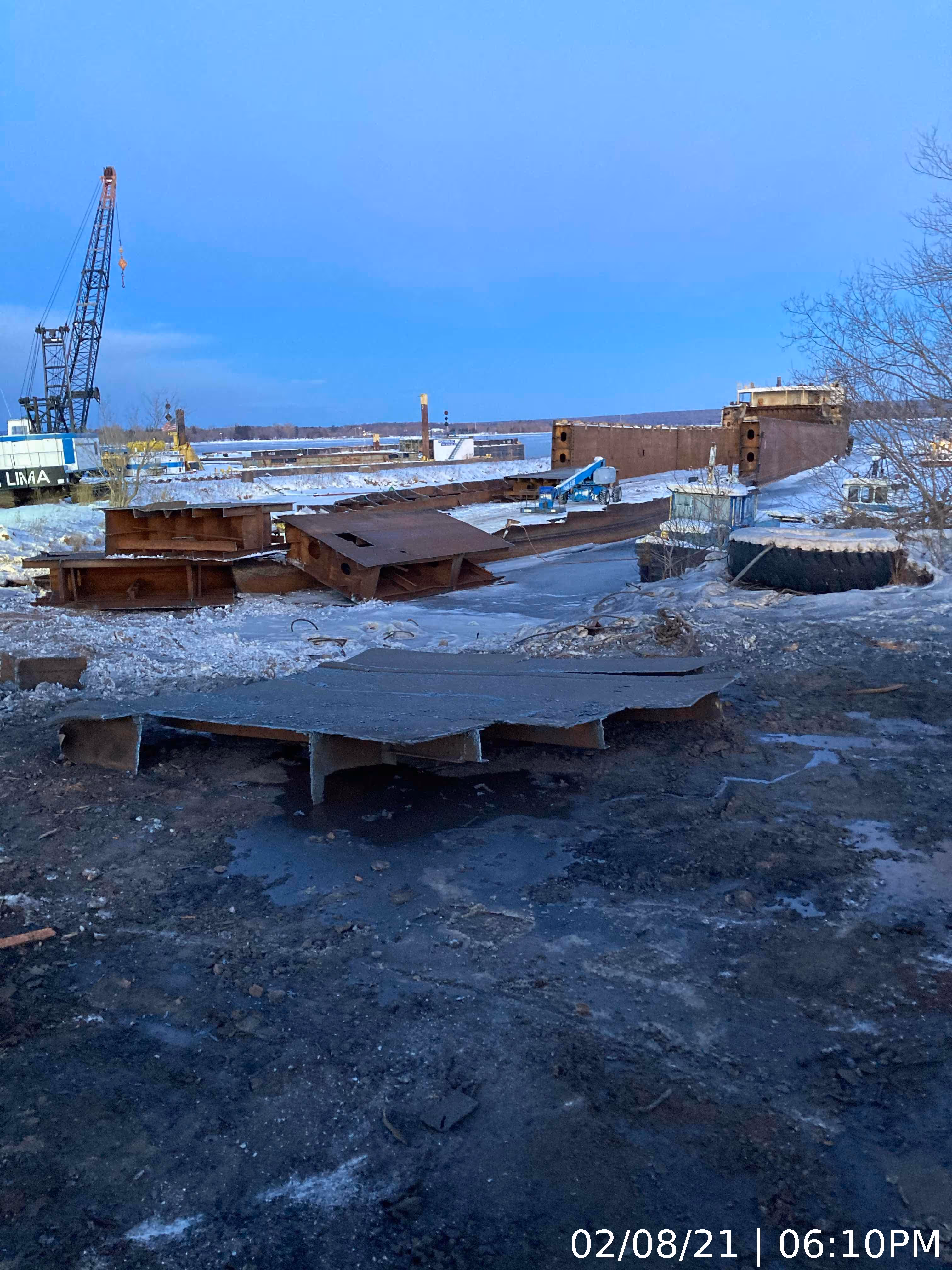 A site of deconstructed metal scraps with machinery in the background cleaning it up.