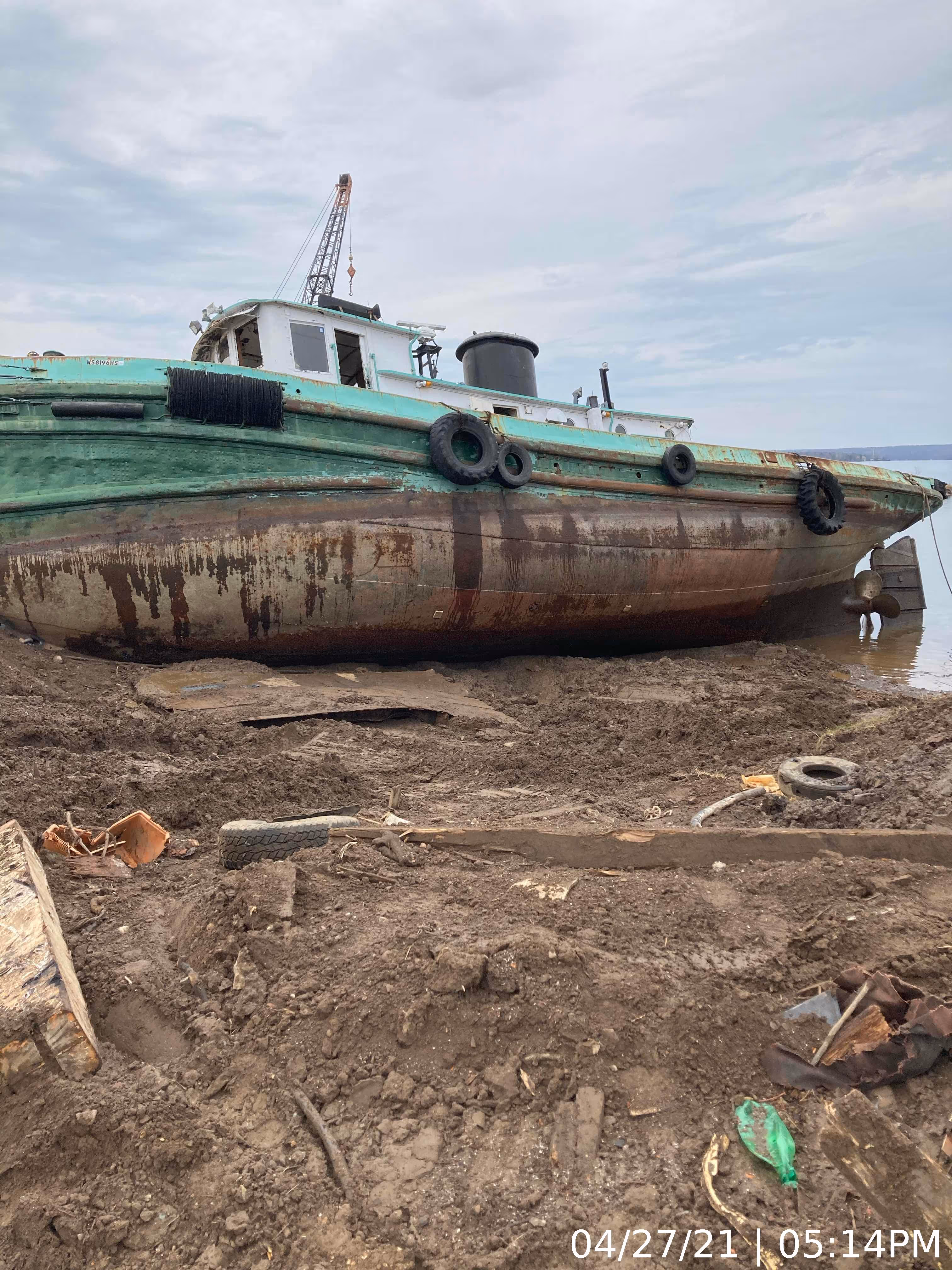 A boat sits on the ground awaiting deconstruction