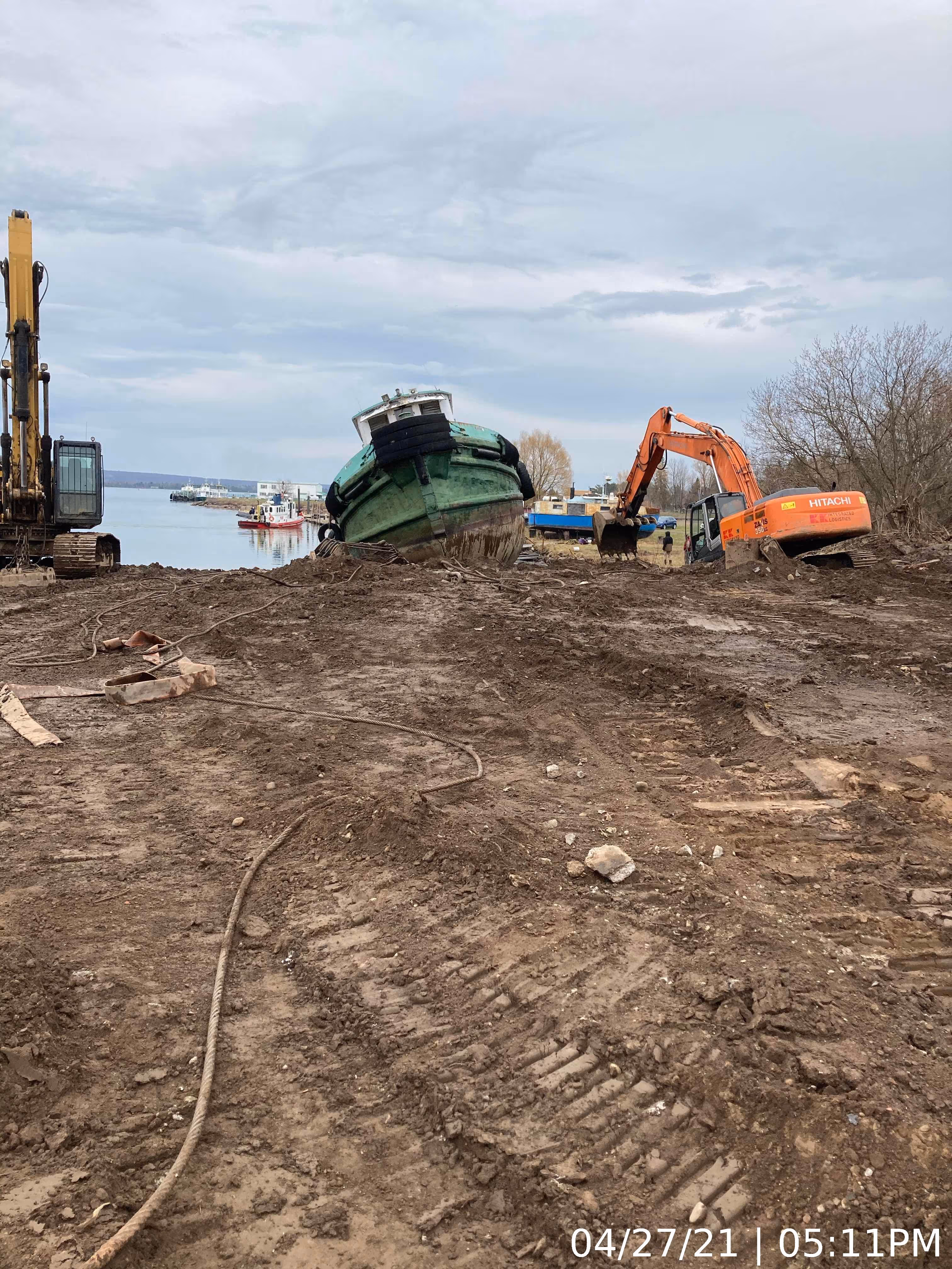 A boat is positioned on the ground next to a crane, suggesting maintenance or loading activities.