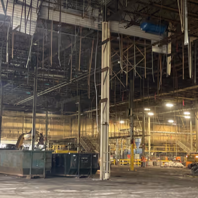 Demolition in progress with high scaffolding and debris piles