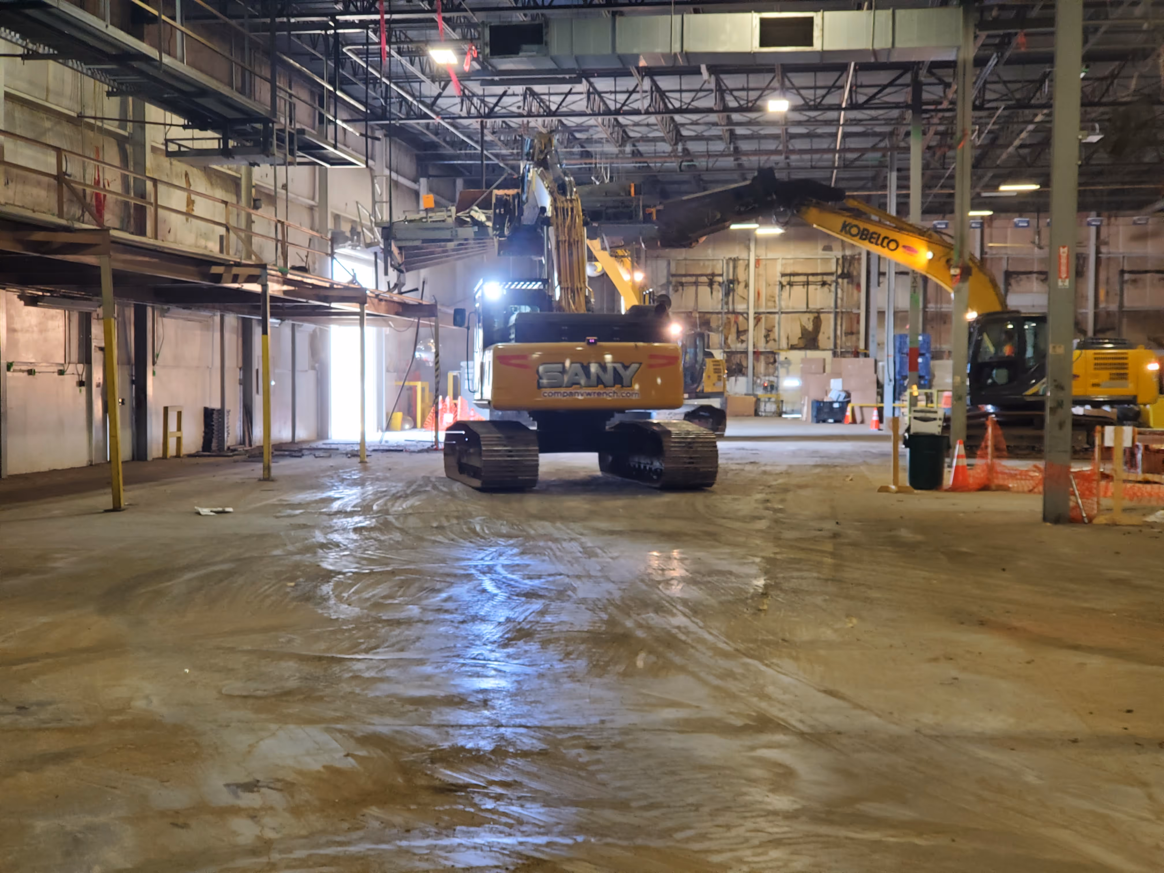 Skid steer clearing debris inside large industrial facility