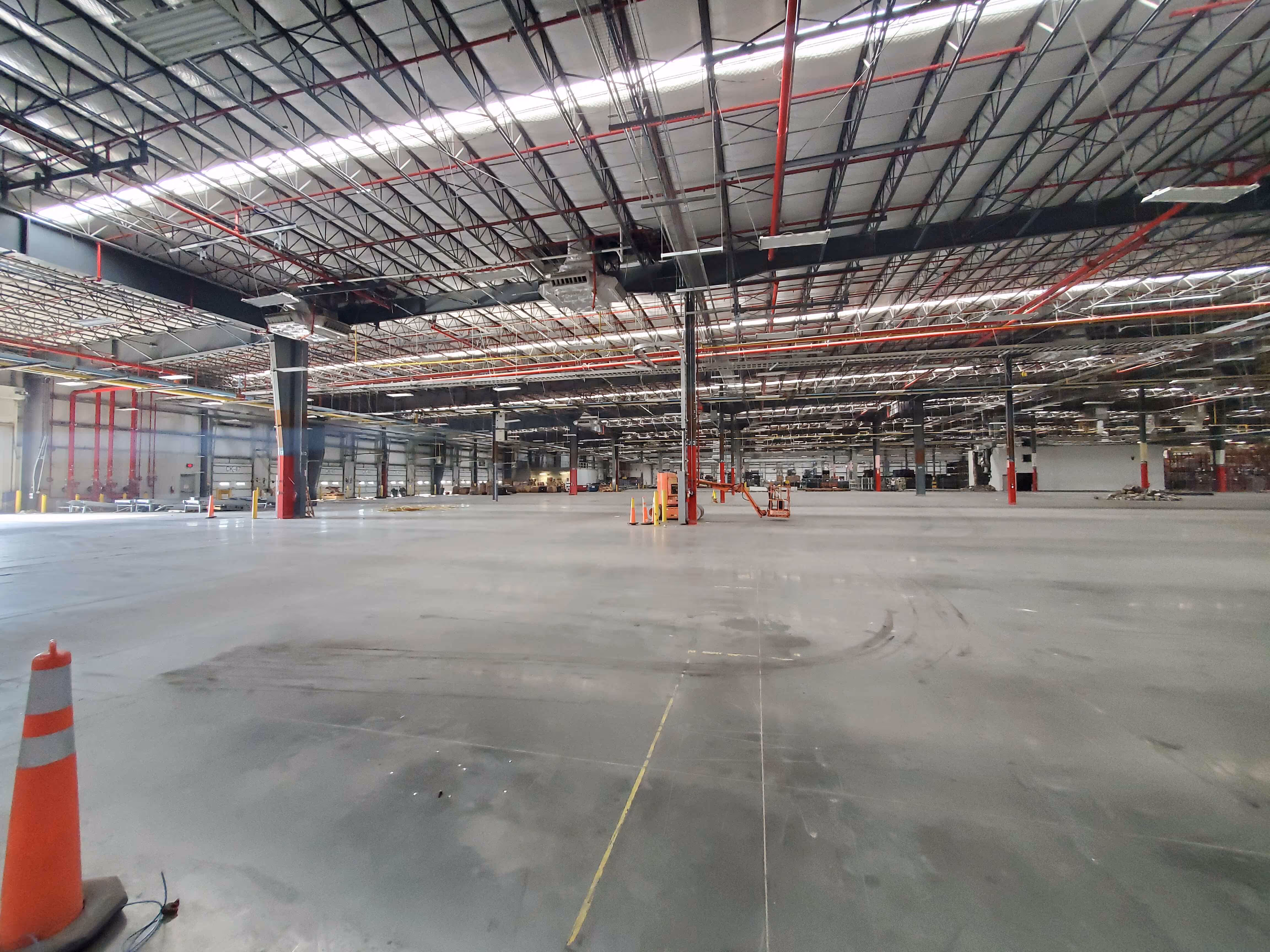 Cleared warehouse floor with safety cones and high-bay lighting