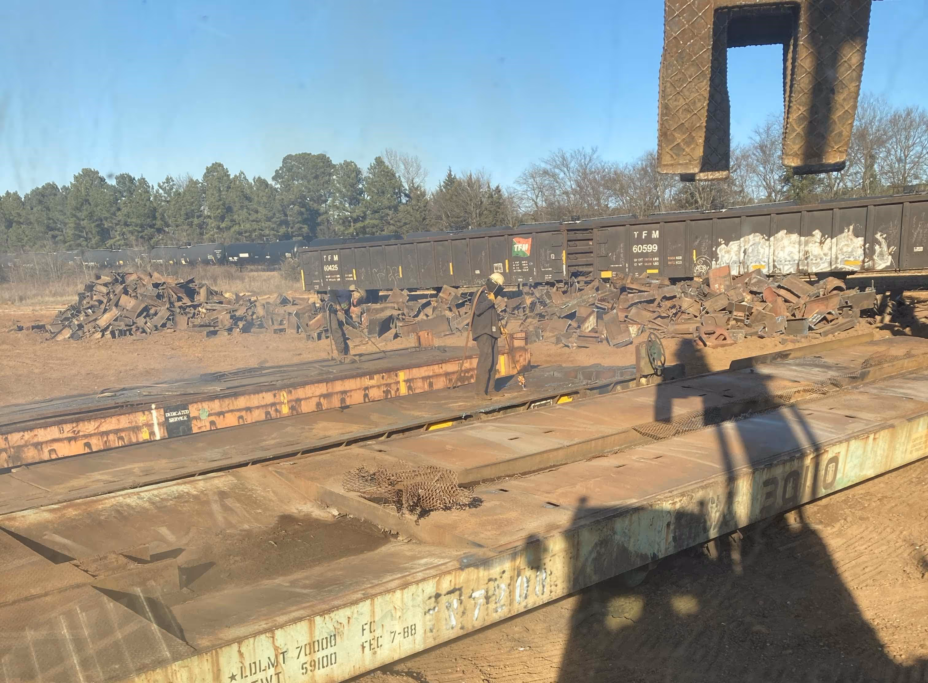 Excavators working on large industrial teardown in wooded area