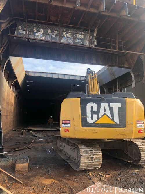 A yellow CAT construction vehicle is parked in a large building.