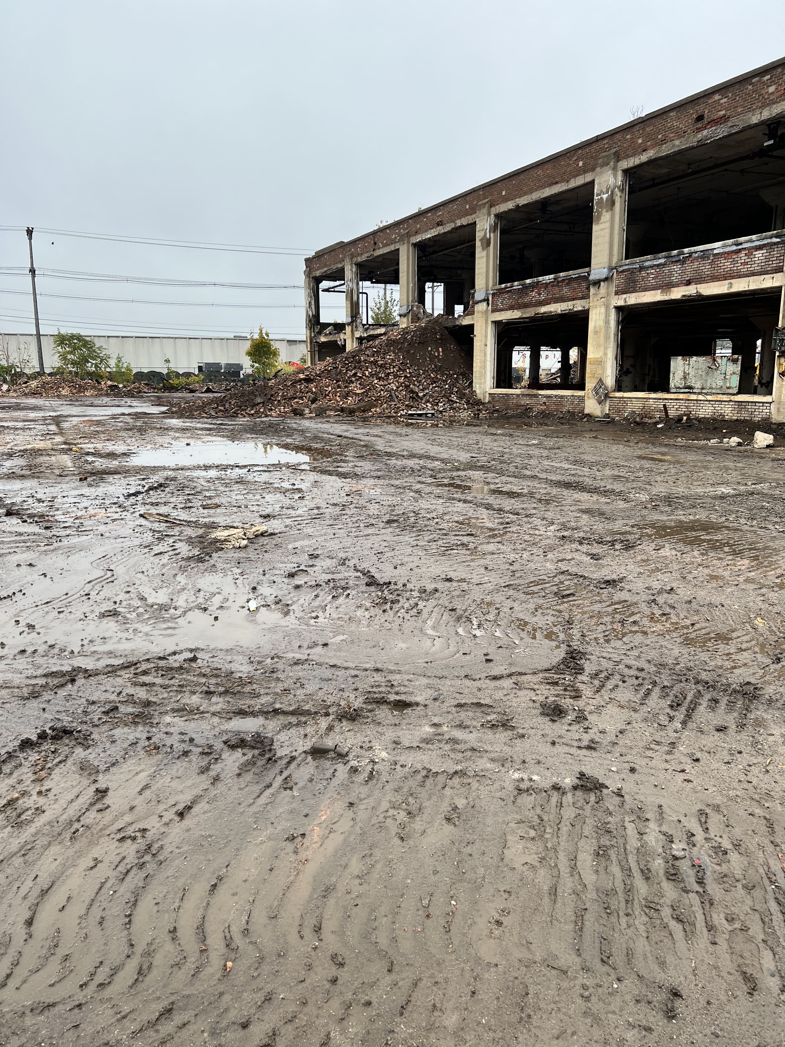 A muddy lot with a building in the background.