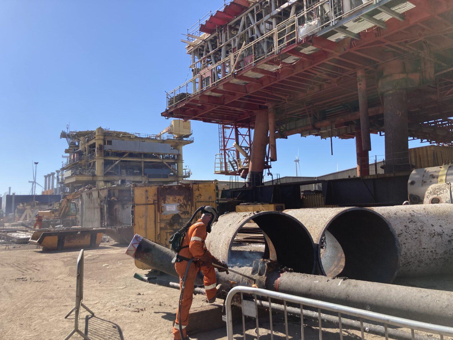 A man working on a pipe in a construction area.