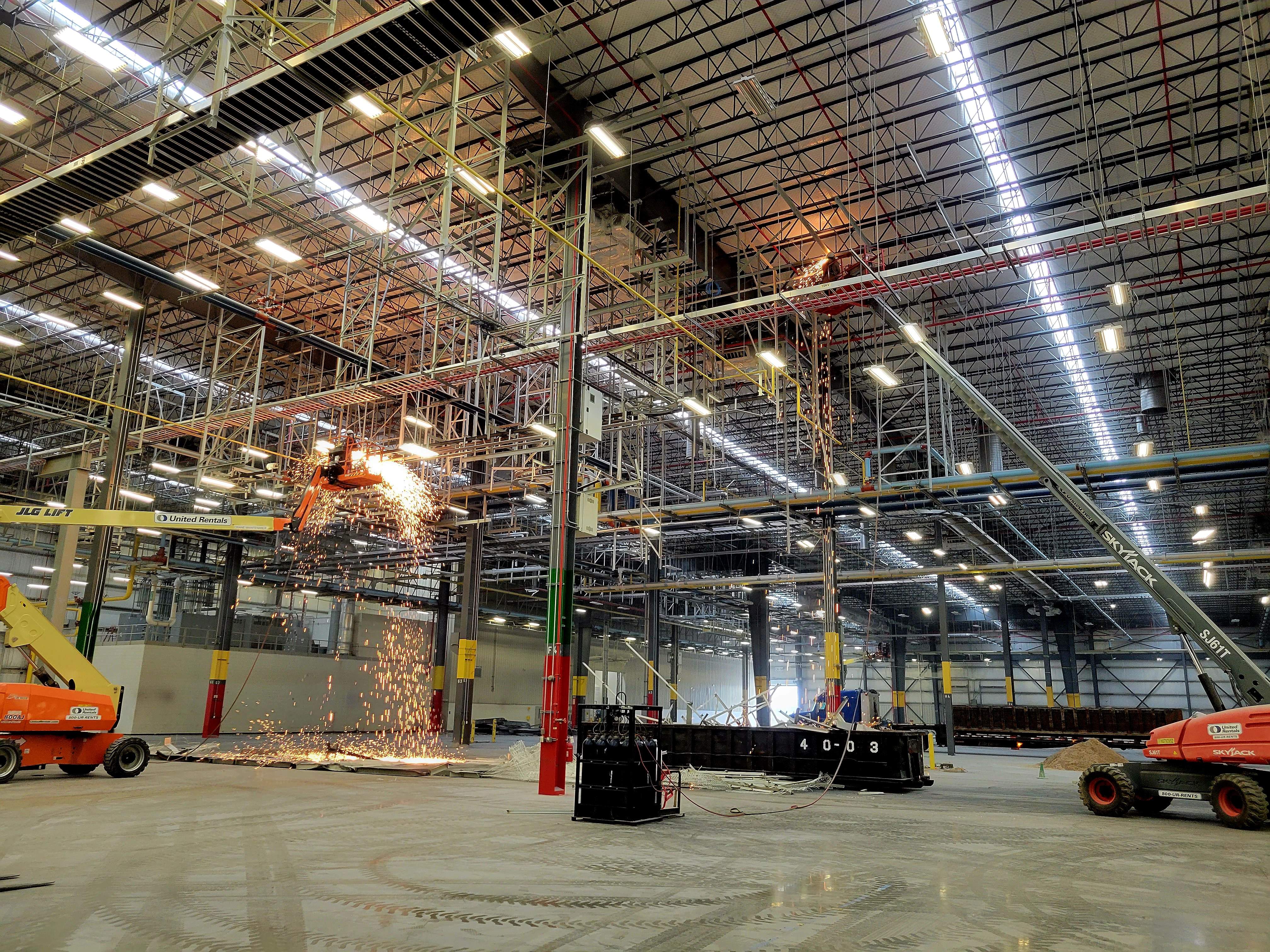 Interior view of a large warehouse undergoing full-scale industrial dismantling