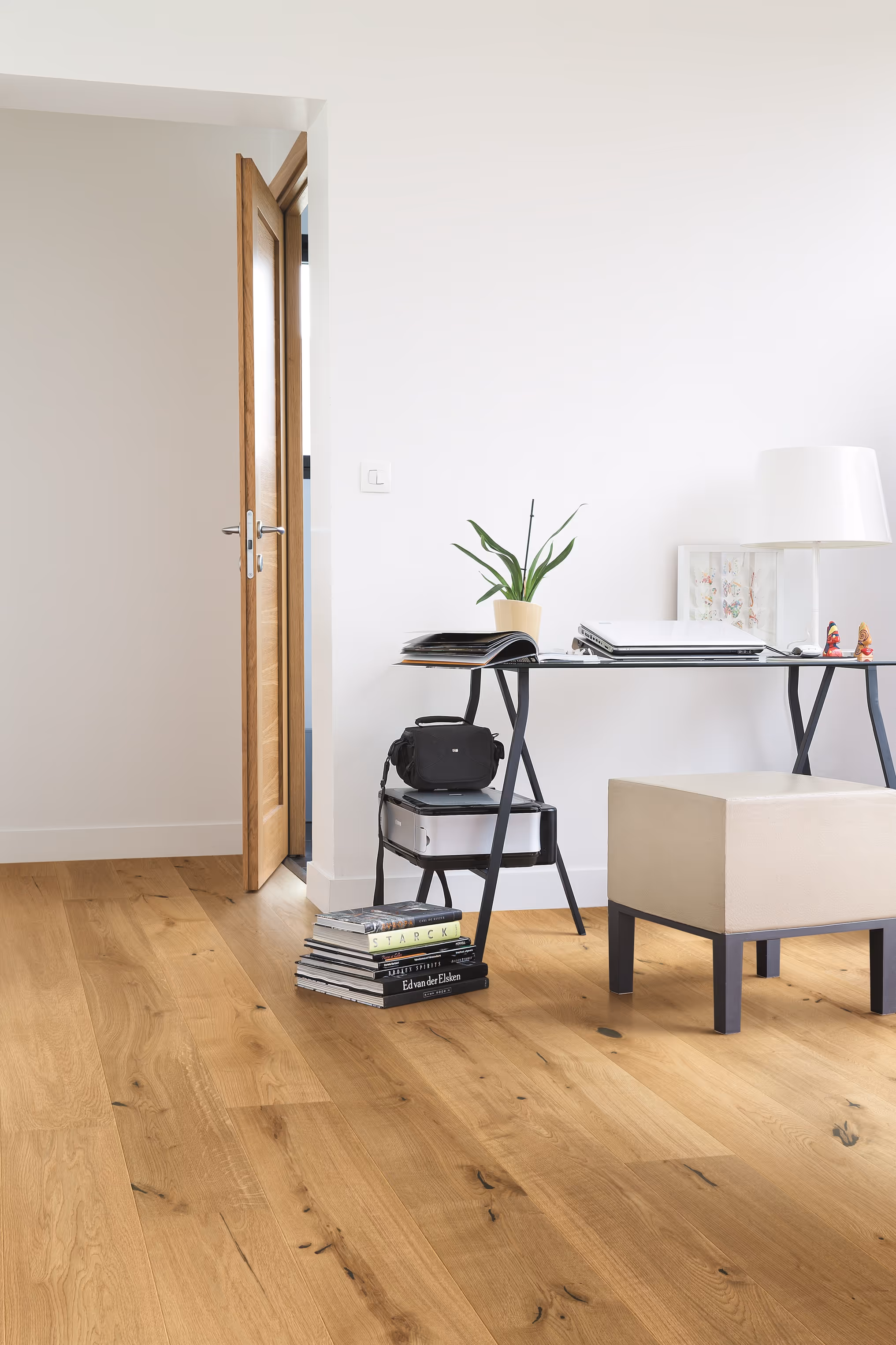 a desk with a chair and a plant in a room