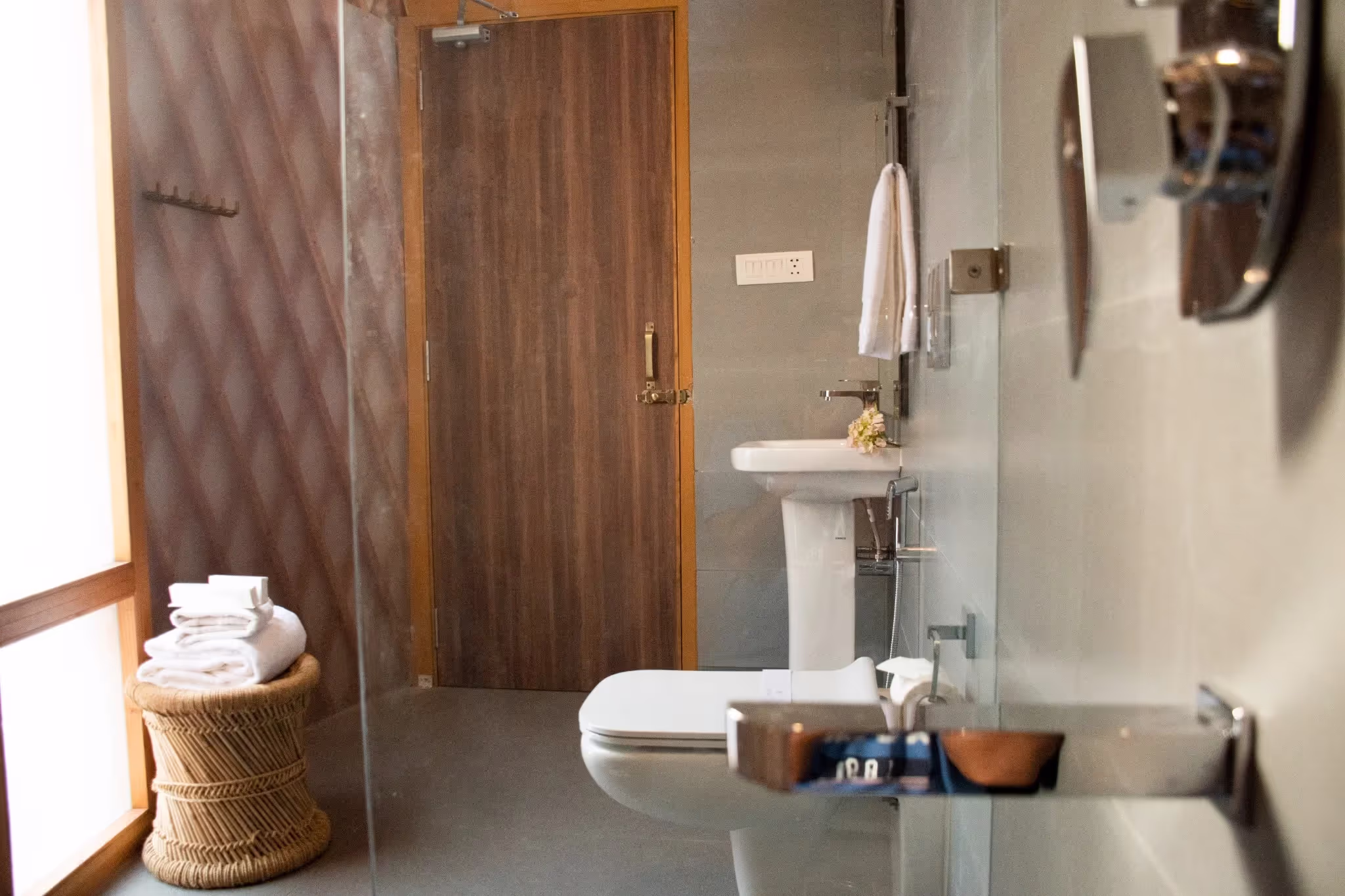 Luxury yurt bathroom showcasing modern amenities like a sleek sink, shower area, wicker basket with towels, and natural wood accents.