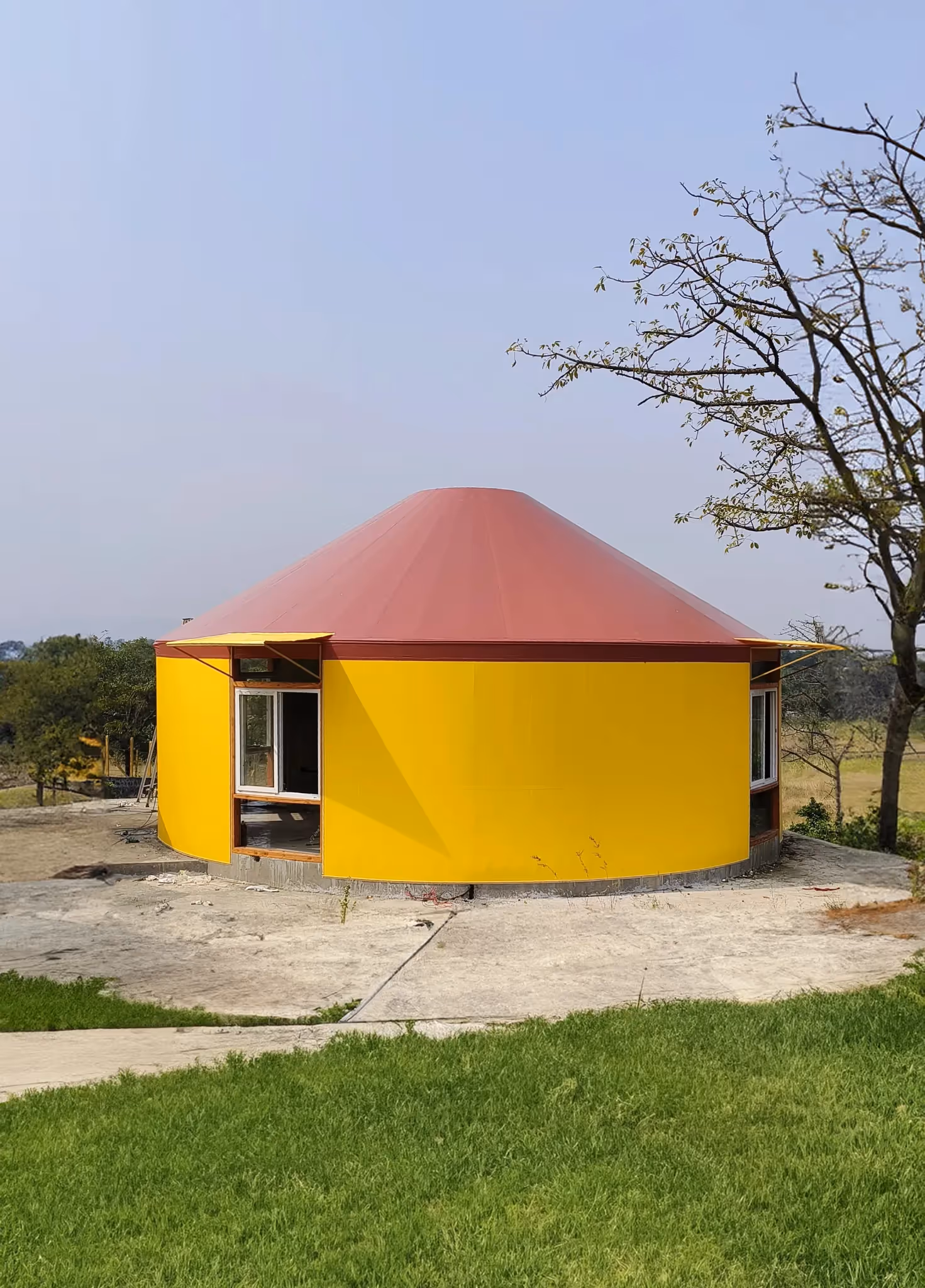 Completed yurt with canvas covering in a scenic location.