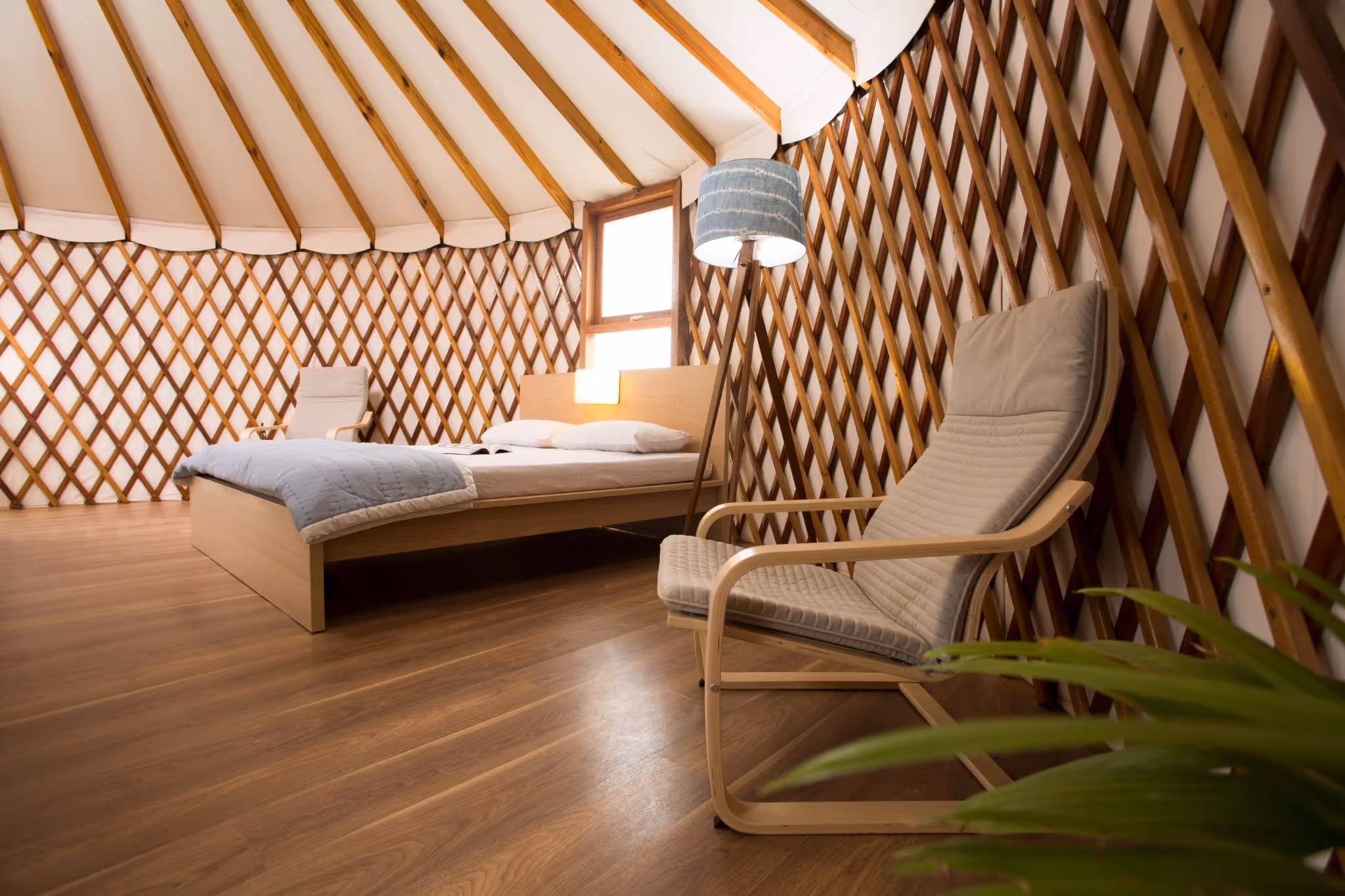 Luxury yurt bedroom with king-size bed and ambient natural lighting