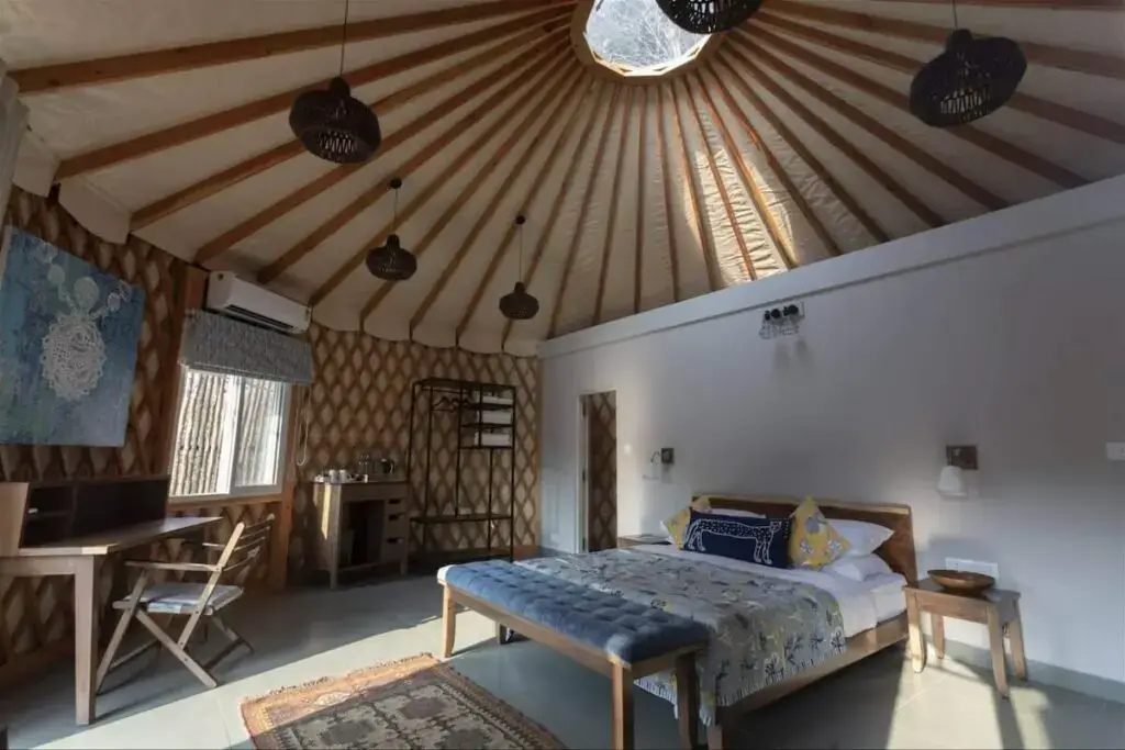Cozy yurt interior featuring a spacious bed and rustic decor elements.