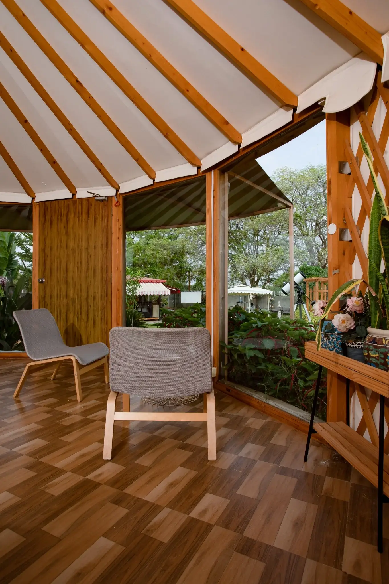 Cozy seating arrangement inside a luxury yurt with natural light and garden views.