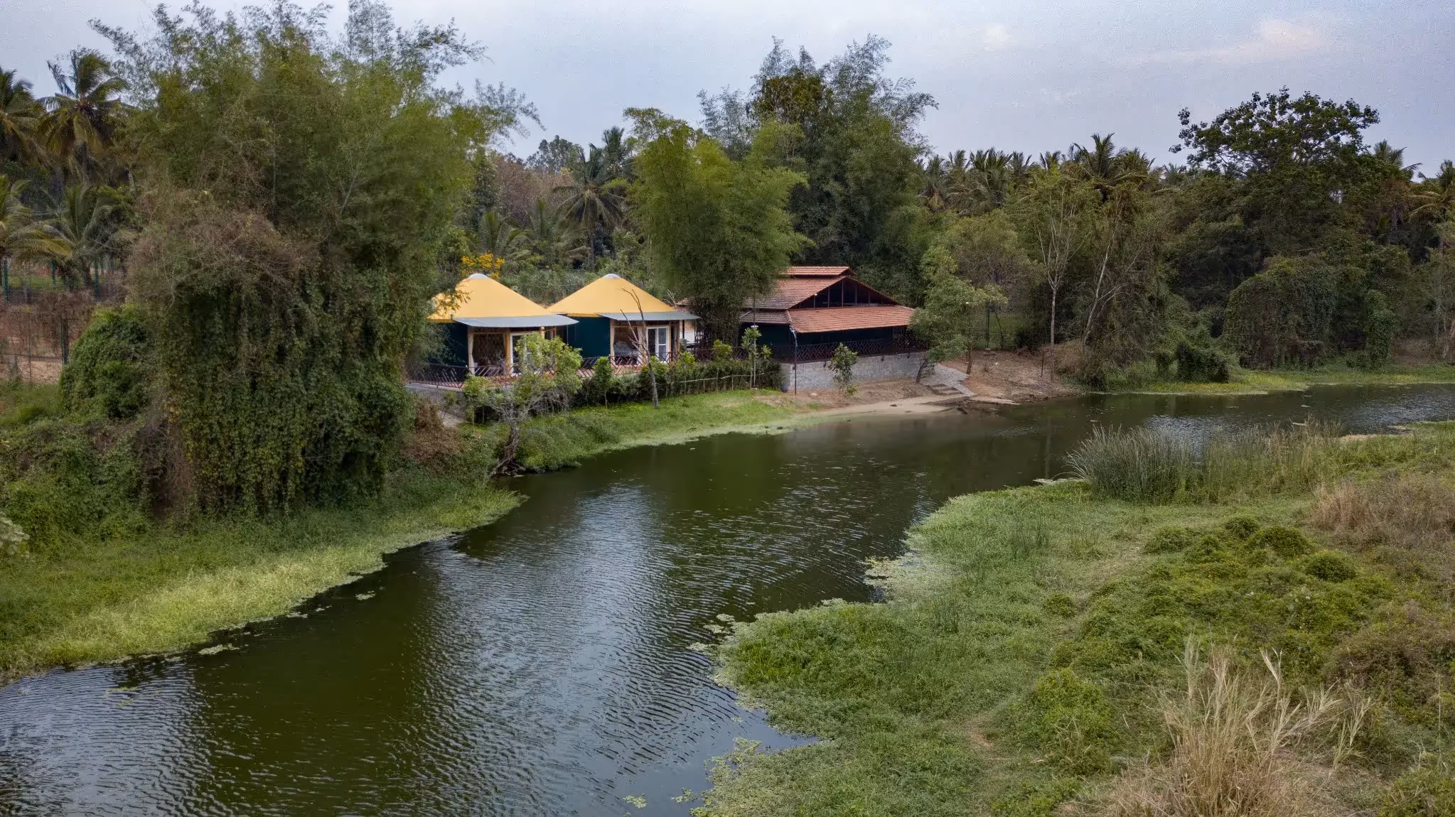 Scenic riverside glamping resort with eco yurts and natural surroundings in a forested setting.