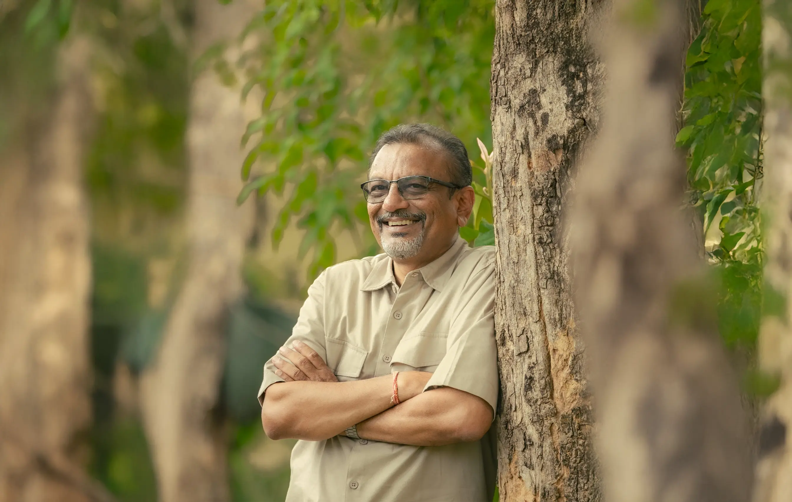 A smiling yurt owner standing in front of their fully set-up yurt, surrounded by natural landscape, with a cozy deck and minimal furnishings visible—capturing their satisfaction and the serene environment.