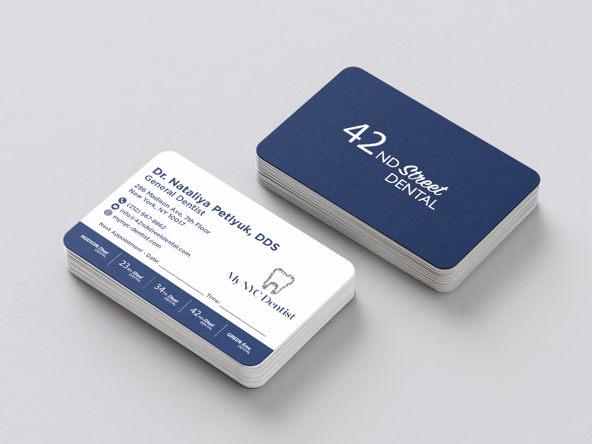 Two stacks of dental appointment cards on a gray surface; one card shows a blue back with white text '42nd Street Dental', the other card front displays Dr. Nataliya Petiyuk, DDS contact info, appointment date and time fields, and the My NYC Dentist logo with a tooth graphic.