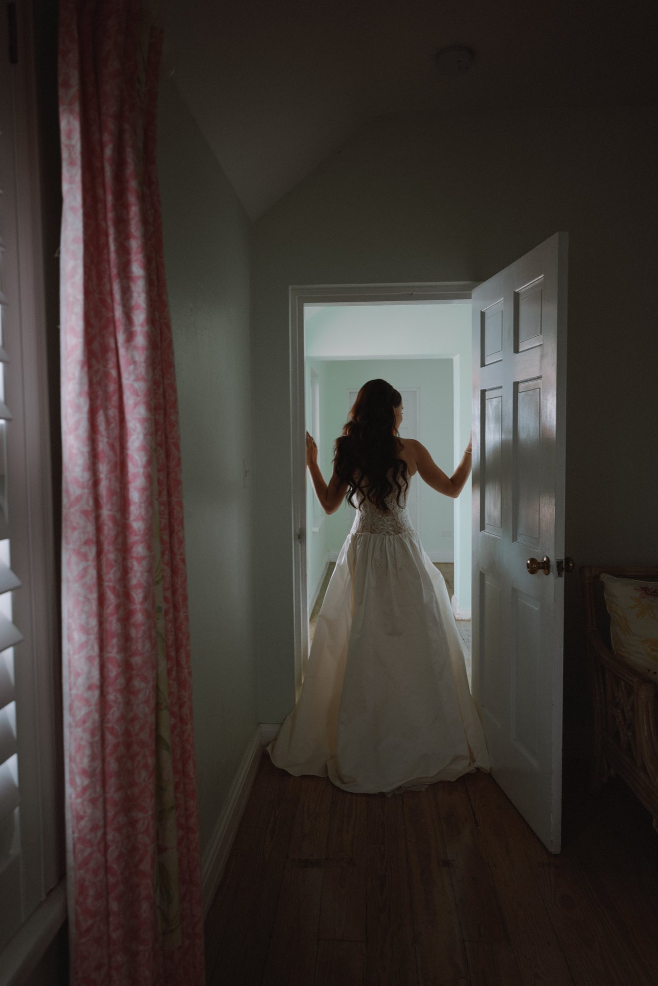 Silhouette of bride with long hair in dramatic doorway light